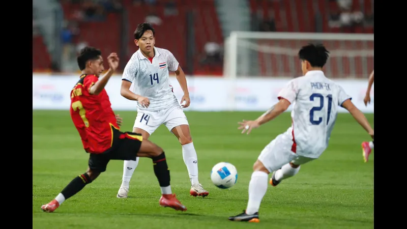 Cầu thủ U22 Thái Lan vượt qua hậu vệ U22 Singapore trong trận đấu bóng đá